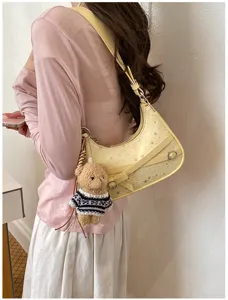 Stylish retro shoulder bag for women, trendy star pattern commuter tote with cute bear pendant.