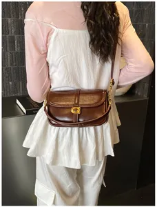 Vue détaillée d'un sac à épaule élégant en cuir marron avec fermoir métallique en C.