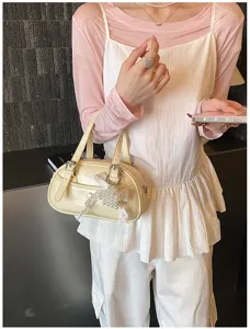 Chic pale yellow bowling shoulder bag with double handles and cute pearl lace charm.