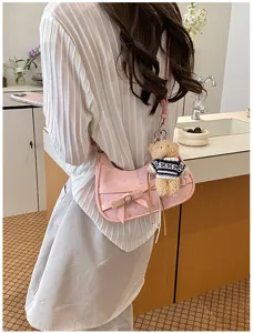 Pink shoulder bag with bow star pattern and cute teddy bear keychain for women commuting chic.