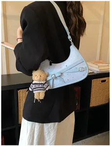 Light blue hobo shoulder bag detail, featuring star print, cute bow, and bear plush pendant.