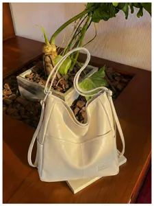 Beige leather tote bag detail, featuring versatile large capacity and retro style design.