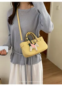 Close-up view of a chic retro leather handbag featuring elegant texture and a cute pegasus charm.