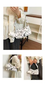 Vista dettagliata della borsa a spalla elegante con stampa doodle bianca e ciondolo nuvola.