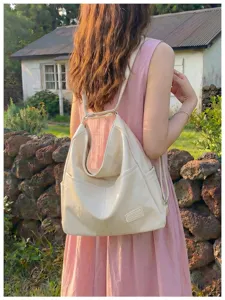 Outdoor detail shot of casual off-white PU leather tote backpack with large capacity.