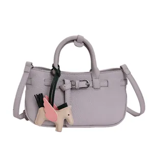 Lilac lychee pattern leather handbag with shoulder strap and a cute pegasus charm.