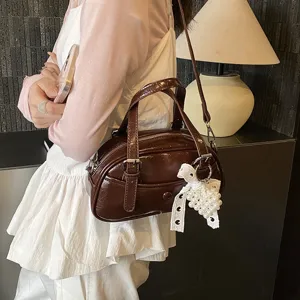 Dark brown patent leather bowling handbag for women, stylish shoulder and crossbody bag with pearls.