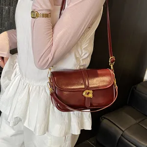 Sac à épaule bordeaux chic en cuir pour femme, élégant sac bandoulière avec boucle dorée.
