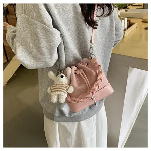 Pink bucket bag detailed view, stylish braided handle, cute bear pendant, soft leather.