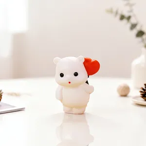 Gedetailleerde close-up van een schattig wit berenbeeldje met een rood hart op tafel.