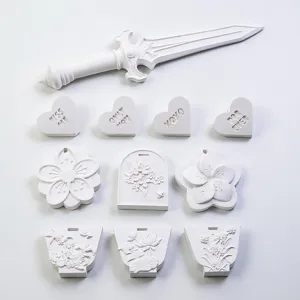 White handmade gypsum plaster aroma stone and silicone mold set featuring floral and sword designs.