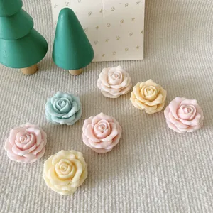 Detailed view of handmade rose flower scented candles or aroma stones in assorted pastel colors.