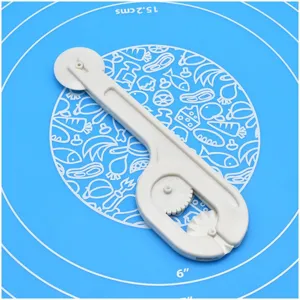 Close-up of white plastic baking pastry wheel cutter and crimping tool detail shot on blue mat.