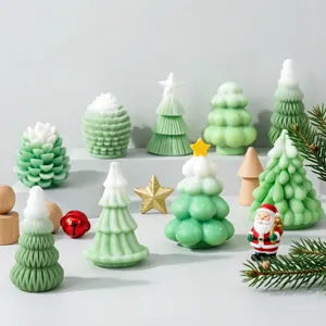 Vue détaillée d'un ensemble de bougies de sapin de Noël vertes et blanches et décor festif.