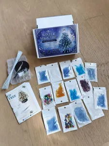 Flat lay view of DIY beaded Christmas tree kit components with colorful beads and box