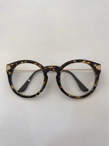 Detailed view of vintage tortoise shell round optical glasses frame with delicate metal temples.