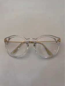 Clear frame optical glasses detail with metal brow bar and hinge rivets. Retro style look.
