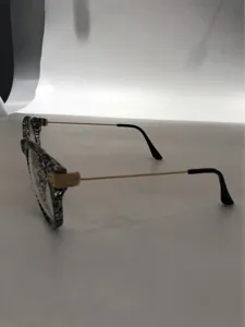 Detailed view of vintage black white speckled frame glasses with slim gold metal temples.