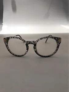 Detailed view of trendy vintage round eyeglasses frame with black and white speckled pattern.