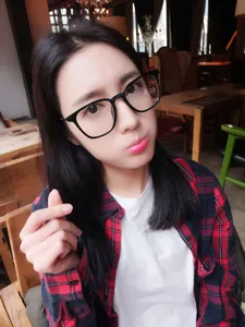 Detailed view of stylish black thick-frame retro glasses worn by a model in a cafe setting.