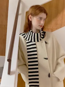 Chic black and white striped scarf paired with elegant beige duffle coat for winter style.