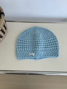 Detail view of light blue crochet knit beanie, breathable hollow out texture, cozy daily wear.