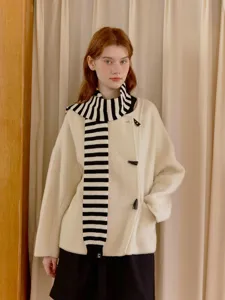 Close-up detail of cozy black and white striped scarf and chic toggle coat outfit style.