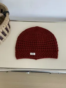Detailed shot of Korean retro hollow knit beanie, cozy dark red winter wool cap texture.
