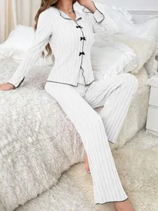 Detail view of women's white ribbed pajama set with elegant black bow ties