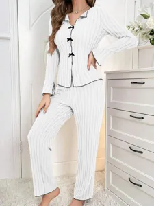 Detailed view of women's white ribbed pajama set featuring black bow accents and piping