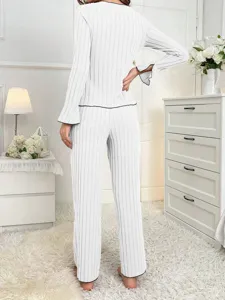Back view of white ribbed long-sleeve pajama set for women in a cozy bedroom setting