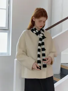 Detailed close-up shot of the trendy black and white striped narrow knit scarf indoors.