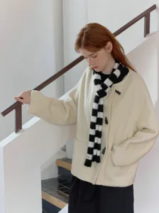 Black and white striped knit scarf paired with warm winter outerwear for chic style.