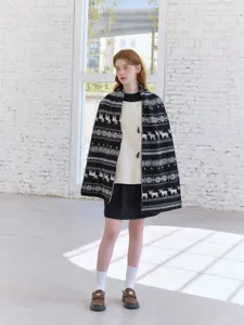 Detailed shot of winter black and white knitted scarf with classic Fair Isle reindeer pattern.