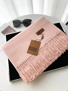 Vista dettagliata della sciarpa invernale rosa effetto cashmere con frange morbide e accoglienti.
