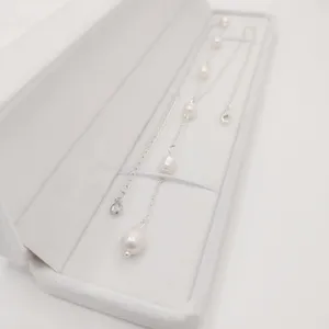 Elegante Detailaufnahme einer Süßwasserperlenkette mit Silberkette in weißer Schmuckschatulle
