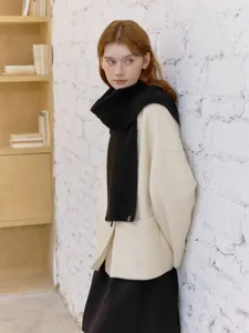 Detailed view of cozy black cable-knit wool scarf elegantly paired with winter outerwear.
