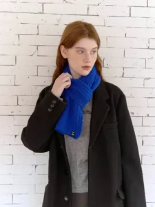 Wool blend cable knit scarf detail showing soft blue texture and stylish cozy neck design.