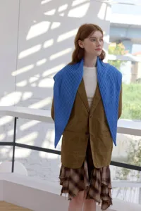 Vista detallada del pañuelo chal triangular de punto, textura acanalada azul, accesorio suave.