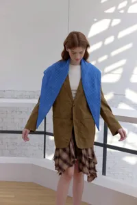 Vista detallada del acogedor pañuelo triangular de punto azul para elegantes conjuntos de otoño.