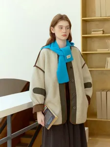 Dettaglio elegante di giacca in pile accogliente e sciarpa in maglia blu invernale.