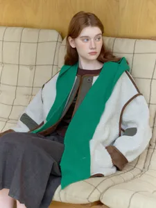 Cozy autumn winter fleece jacket detail showcasing contrast trim and attached knit green scarf hood.