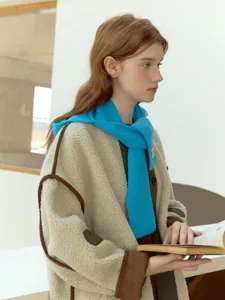 Primo piano della sciarpa in maglia blu e dettagli della giacca in pile per inverno.