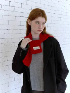 Dettaglio della sciarpa in maglia rossa con trama morbida, accessorio invernale caldo ed elegante.