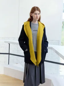 Detailed view of the stylish knit shawl and outerwear combination in modern setting.