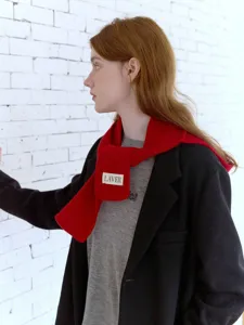 Dettaglio di sciarpa in maglia rossa, elegante accessorio termico per giorni freddi.