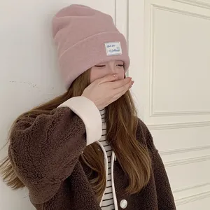 Detailed view of women winter pink wool blend knitted beanie hat, soft warm fashion headwear.
