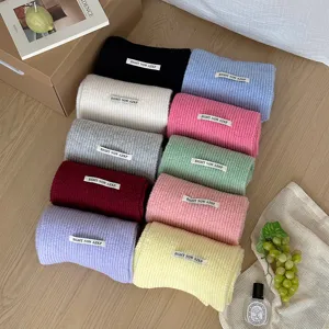 Primo piano dettagliato di sciarpe di lana lavorata a maglia colorate arrotolate ordinatamente.
