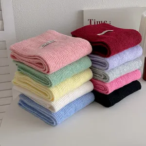 Vista dettagliata di sciarpe in maglia colorata, morbida lana, design a tinta unita calda.