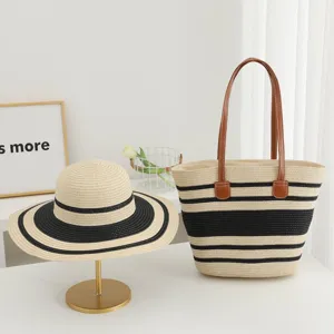 Detail view of stylish straw woven sun hat and striped tote bag set for summer beach vacation.